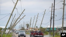 فائل - 30 اکتوبر 2020 :امریکی ریاست لوزیانا میں سمندری طوفان زیٹا کے گرینڈ آئل سے ٹکرانے کے بعد بجلی کی لائنیں سڑک کی طرف جھک گئیں۔