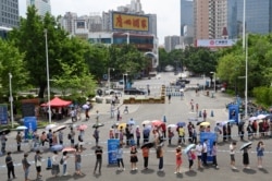 چین کے شہر گوانگ ژہو میں لوگ ویکسین لگوانے کے لیے لمبی قطار میں کھڑے ہیں۔ نئی رپورٹس کے مطابق ویکسینز اومیکرون کے خلاف کم موثر ہے۔