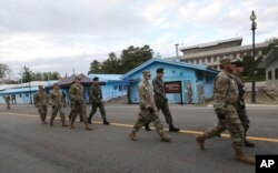 جنوبی کوریا اور امریکی فوج کے سپاہی سرمئی یونیفارم میں پین مونجوم کے ڈی ملٹرائزڈ زون میں پہرہ دے رہے ہیں۔ فائل فوٹو